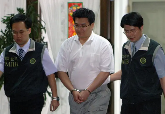 2006年6月2日,台湾总统陈水扁的女婿赵建铭(中)在台北办公室接受调查局人员的讯问后被带走。陈水扁总统所在的民进党因涉嫌内幕交易而陷入动荡,其女婿赵建铭被指控牵涉其中。该指控引发了对陈水扁家族的强烈批评。