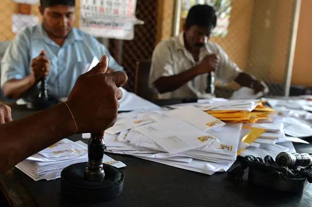 Sri Lankan postal service's employees stamp letters at the General Post Office in Colombo on October 3, 2013. AFP PHOTO/ Ishara S. KODIKARA (Photo credit should read Ishara S.KODIKARA/AFP via Getty Images)
