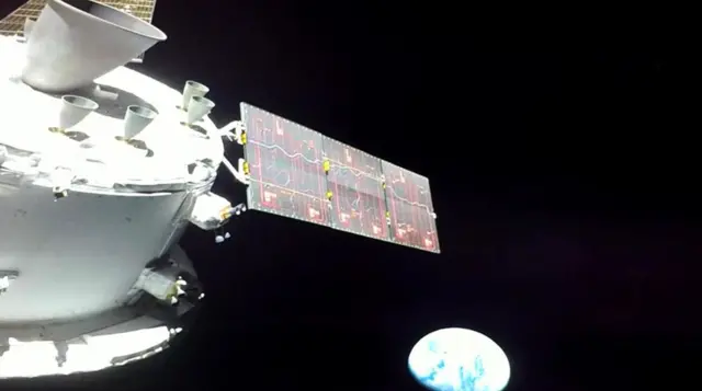 The Orion capsule looks back towards the Earth