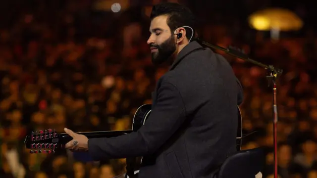 Gusttavo Lima tocando violão durante show