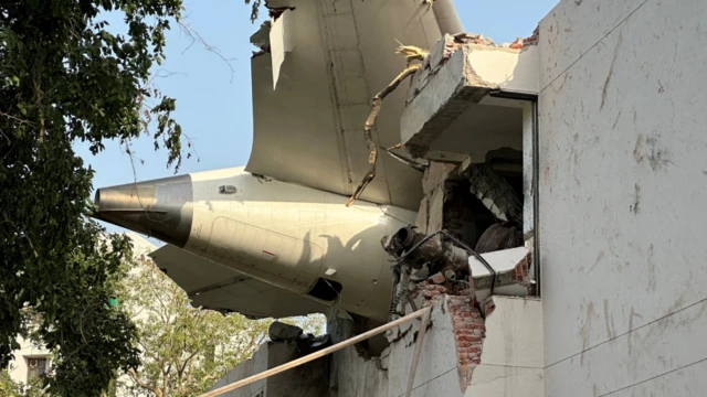 El motor del avión empotrado en un edificio.