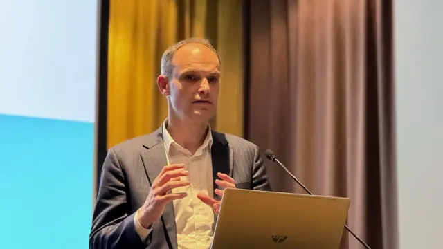 Političar Anže Logar u odelu za govornicom