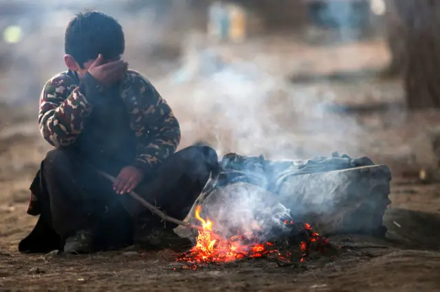 کودکی در کابل کنار آتش نشسته