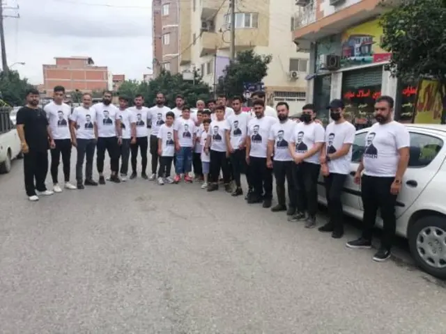 تصویری از دوستان محسن با تی‌شرتی که تصویر او بر رویش نقش بسته