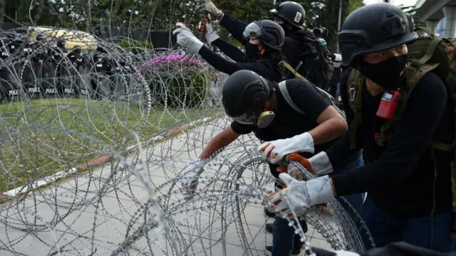 Таиландда өкмөткө каршы демонстранттар митинг учурунда тикенек зымдарды алып салууда