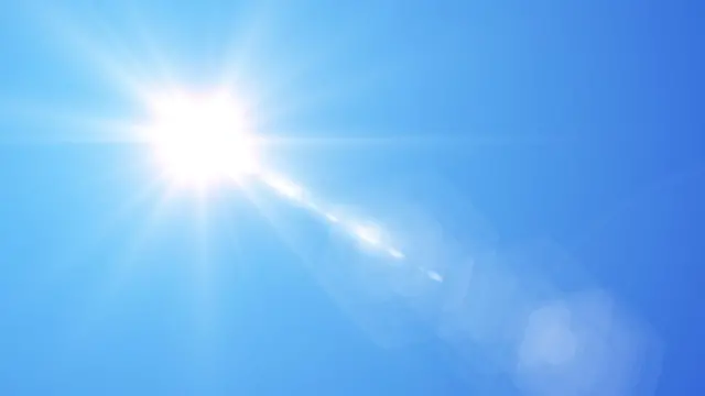 Sol brillando en cielo azul.