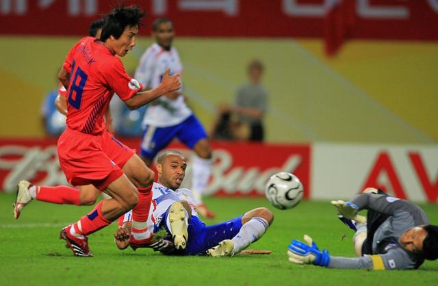 Trung vệ Kim Sang-sik (áo đỏ) cản phá chân sút Thierry Henry của Pháp trong trận Hàn Quốc cầm hòa Pháp 1-1 tại bảng G World Cup 2006