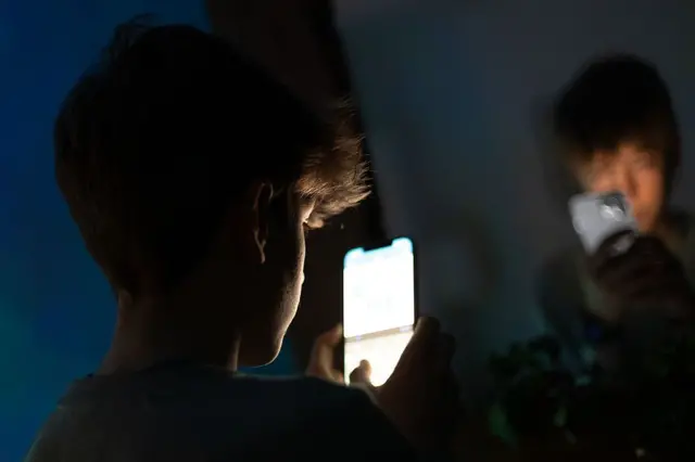 Подросток смотрит в экран телефона