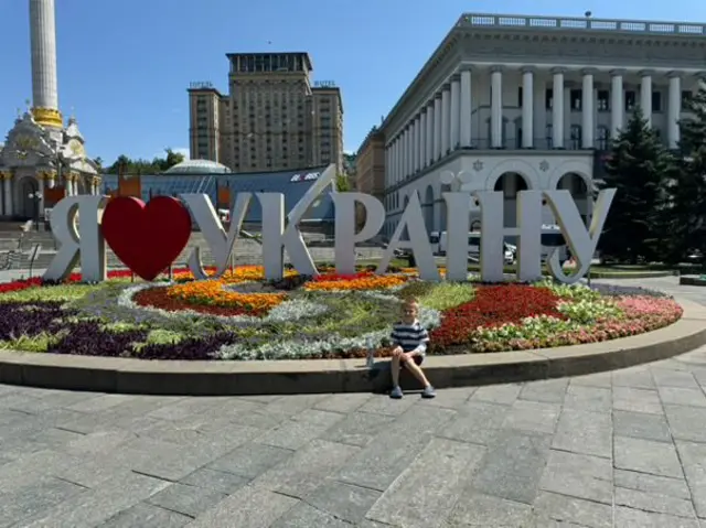 Хлопчик на Майдані у Києві на тлі напису "Я люблю Україну"