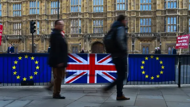 People walking past flags in Westminster
