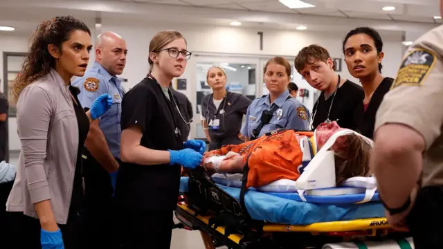 Кадр із фільму - медпрацівники у лікарні стоять біля каталки, на якій лежить закривавлений пацієнт