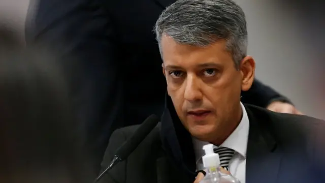Dias com olhar sério enquanto escuta senador na CPI