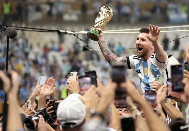 Lionel Messi (Argentine) célèbre la victoire avec le trophée du vainqueur de la Coupe du Monde de la FIFA, Qatar 2022, lors de la finale opposant l’Argentine à la France le 18 décembre 2022 à Lusail, au Qatar. 