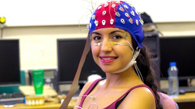 Una joven con electrodos conectados a su cabeza.