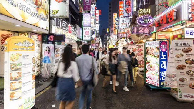 People wander in the street of the Insadong shopping and entertainment district lined with bars and restaurants at night.