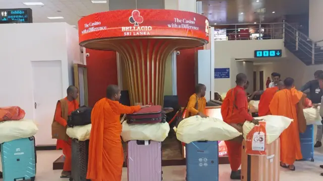 අත්අඩංගුවට පත් භික්ෂුන් වහන්සේලා ගුවන්තොටුපළ තුළ තම ගමන් මලු සමග