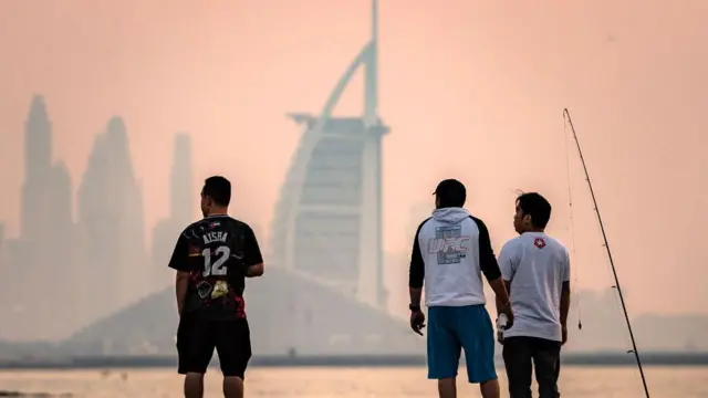 2025年1月31日，人們手持釣竿，杜拜天際線（包括帆船酒店）為背景。 