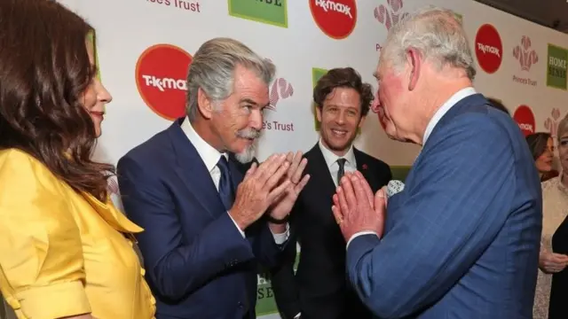 MARCH 11: Prince Charles, Prince of Wales uses the Namaste gesture to greet Anna Friel and Pierce Brosnan as he attends the Prince"s Trust And TK Maxx ^ Homesense Awards at London Palladium