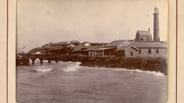 منہوڑا کے لائٹ ہاؤس اور اس کے ساتھ موجود عمارتوں کی تصویر، جو 1900 میں لی گئی تھی