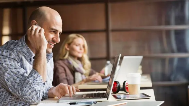 Una persona hablando por teléfono en una oficina abierta