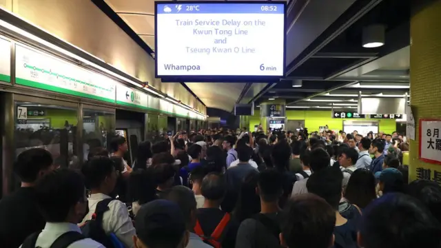 列车无法开出，月台挤满无法上车的乘客。