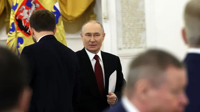 Путін в костюмі в оточенні людей в костюмах