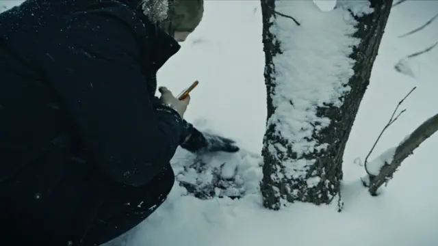 Maksim qorda daraxt tagiga narsa ko'mayapti