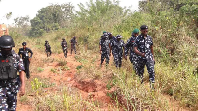 Awọn ọlọpaa n rin kiri ninu igbo kan.