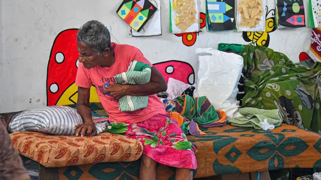 වැඩිහිටි පුද්ගලයෙකු ඇදක වාඩිවී සිටින අයුරු