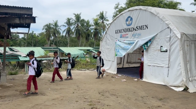 Beberapa murid SDN 5 Peusangan Siblah Krueng mengunakan getek menuju sekolah mereka.