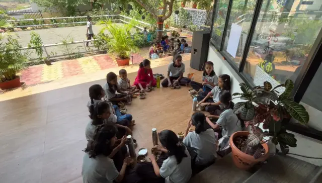 शाळेच्या आवाराज डबा खाणारी मुलं