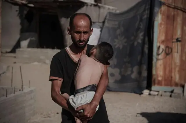 ਗਾਜ਼ਾ ਵਿੱਚ ਇੱਕ ਵਿਅਕਤੀ ਬੱਚੇ ਨਾਲ