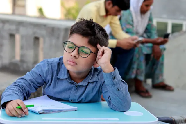 लहान मुलगा डोळ्यांची तपासणी सुरू असताना