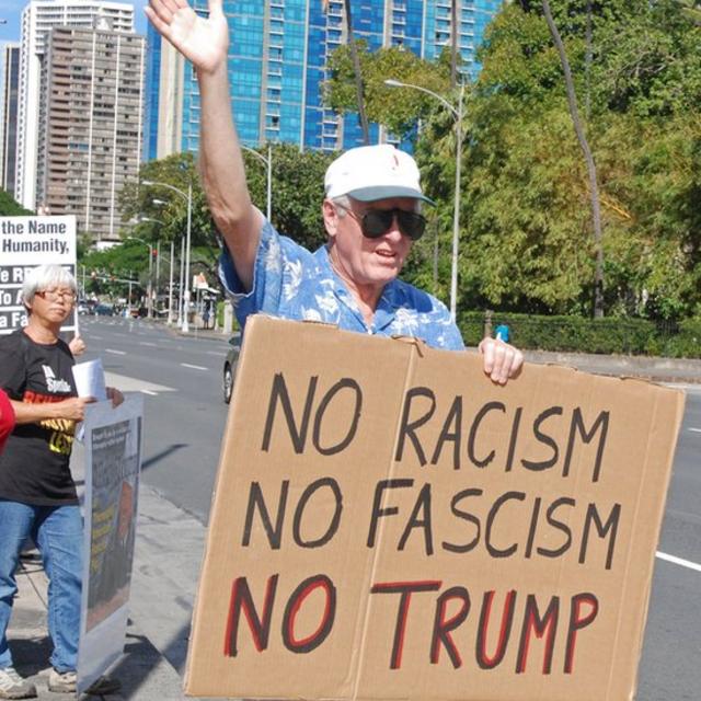Un manifestante con una pancarta que dice: No al racismo, no al fascismo, no a Trump