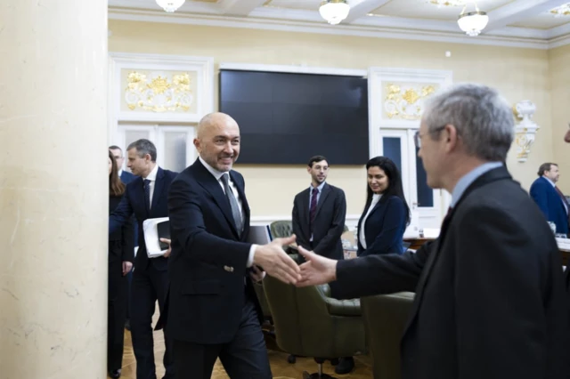 На фото - голова НБУ Андрій Пишний вітається із головою місії МВФ Гевіном Греєм, на задньому тплані ліворуч - міністр фінансів України Сергій Марченко