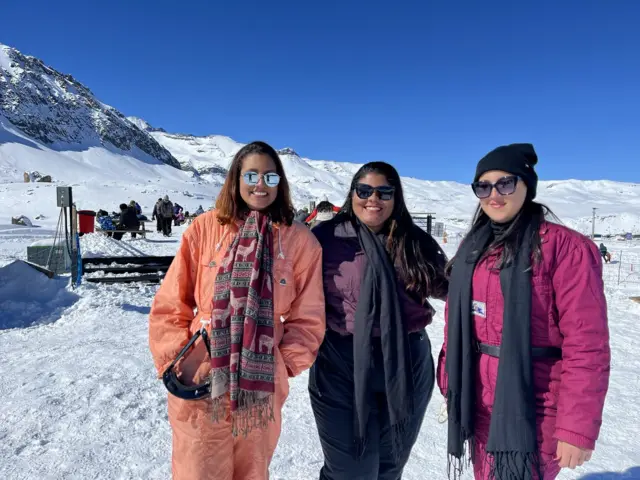 Três amigas próximas e sorrindo