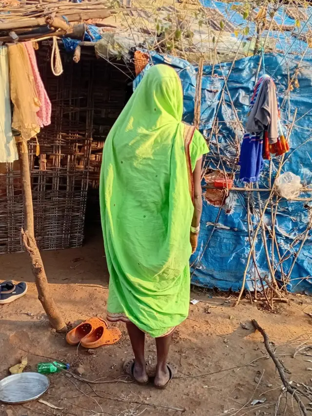 झोपडीबाहेर उभ्या असलेल्या सुगीबाई