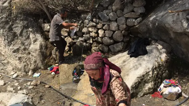 люди набирают воду у родника