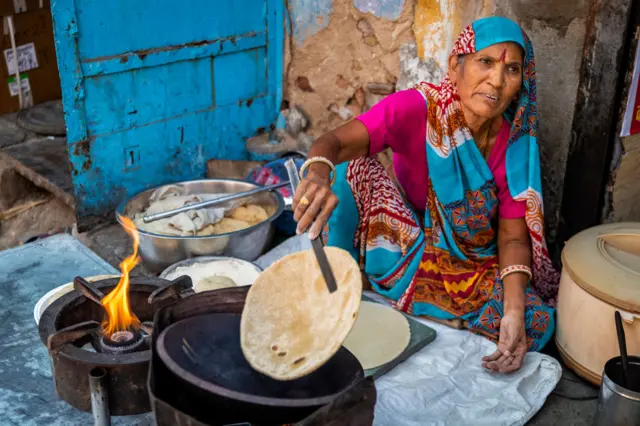 चुलीवर रांधणारी स्त्री 