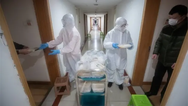 Staff in protective clothing distribute food to patients that were quarantined in a hotel in Wuhan City, Hubei Province, China, 05 February 2020.