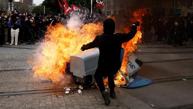 Protesters stand near burning garbage bins during a demonstration as part of the ninth day of nationwide strikes and protests against French government's pension reform, in Nantes, France, March 23, 2023.