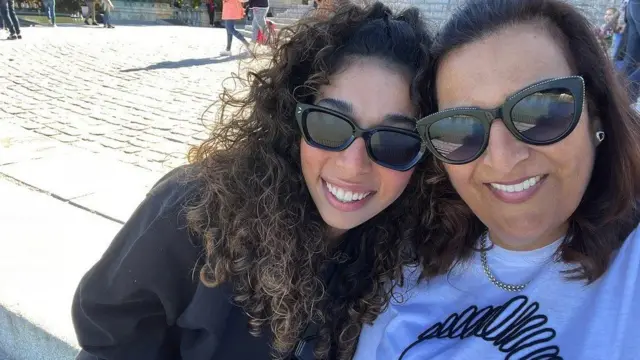 Shahaf and her mum, for foto dey smile and wear sunglasses on a sunny day