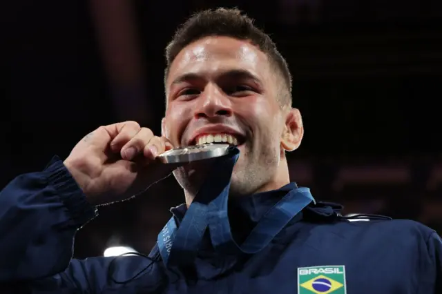 Willian Lima mordendo medalha