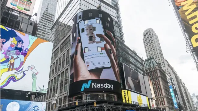 Fotografia colorida mostra um outdoorwww h2betNova York com uma imagem do aplicativo da Nasdaq