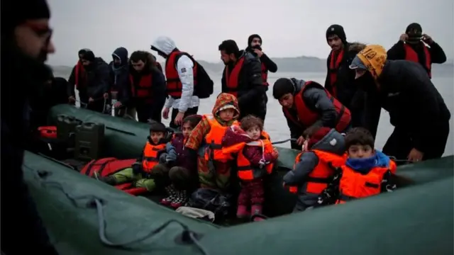 A group of more than 40 migrants with children get on an inflatable dinghy, as they leave the coast of northern France to cross the English Channel, near Wimereux, France, November 24, 2021.