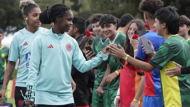 Linda Caicedo, jugadora de la selección colombiana de fútbol, recibe flores de hinchas
