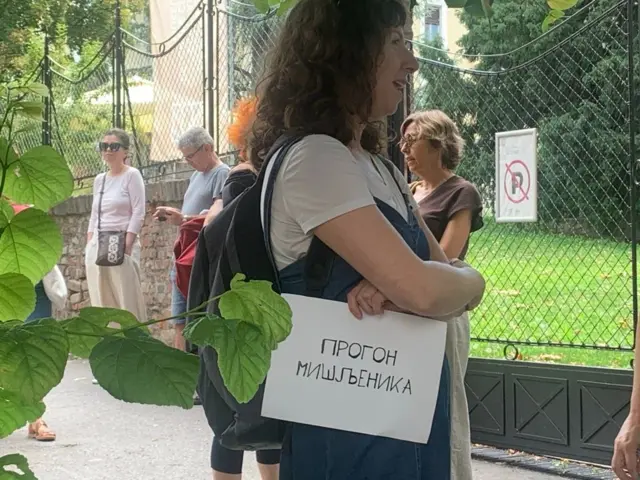 Žena drži transparent u ruci