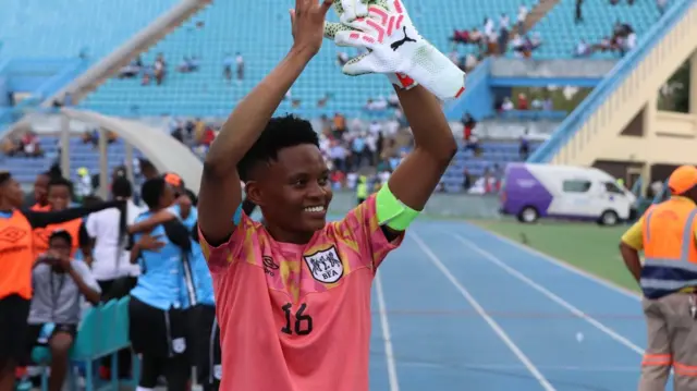 La gardienne de but botswanaise Sedilame Bosija applaudit après un match de football en levant les bras au-dessus de sa tête.