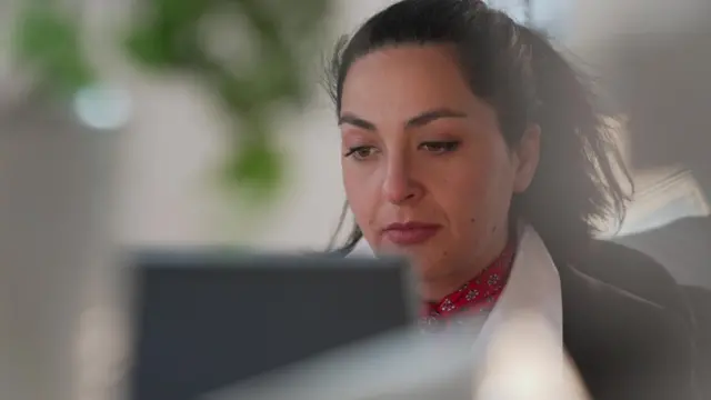 Angela sitting at the laptop