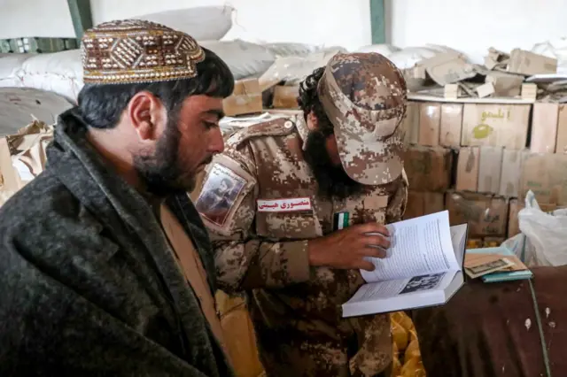 Talibanes revisando libros para prohibir.